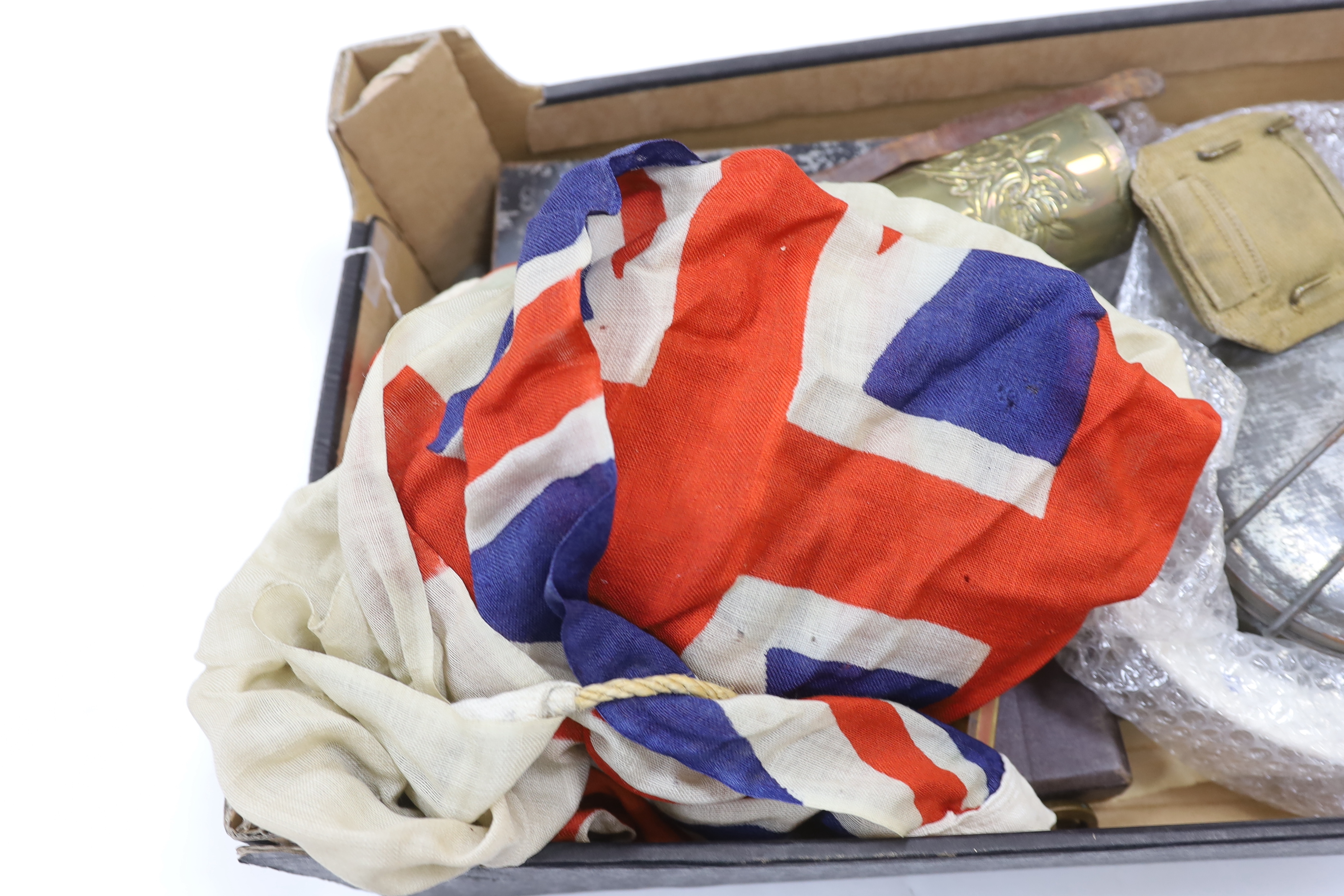 A collection of militaria including; a pith helmet, a T.G. Co. Ltd. Mk.III compass, a cased protractor, a Union flag, a trench art shell casing, a bayonet, an Indian knife, a mess plate with ERII cypher, etc.